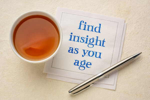 find insight as you age inspirational note - handwriting on a napkin with a cup of tea, againg well, life time experience and personal development concept