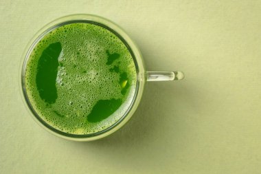 Bir bardak taze ev yapımı yeşil salatalık suyu. Fotokopi alanı olan bir arka planda. Sağlıklı beslenme konsepti.
