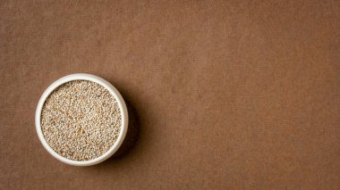 organik beyaz chia tohumları Omega-3 yağ asitleri bakımından zengin, el yapımı bir kağıt üzerinde küçük bir seramik kase