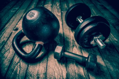 Taşralı ahşap arka planda ağır demir çaydanlık - fitness konsepti, lenssiz iğne deliği kamerası ile siyanotip tonlama görüntüsü ile yumuşak odak