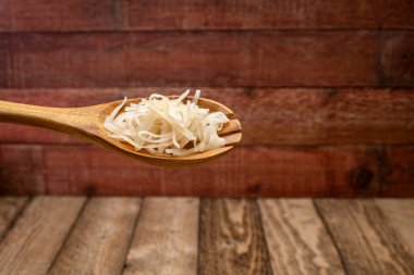 sauerkraut (mayalanmış lahana) ahşap bir kaşık üzerinde rustik barnwood arka planına karşı, probiyotik konsepti - mayalanmış yiyecekler mide sağlığı için iyidir