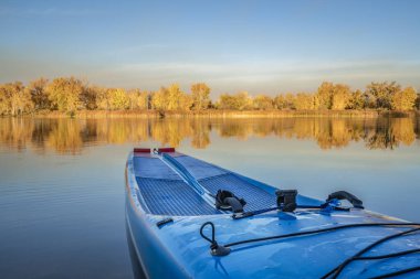 Kuzey Colorado 'nun sonbahar manzarasında sakin bir gölün üzerinde emniyet tasmasıyla raket kalkıyor..