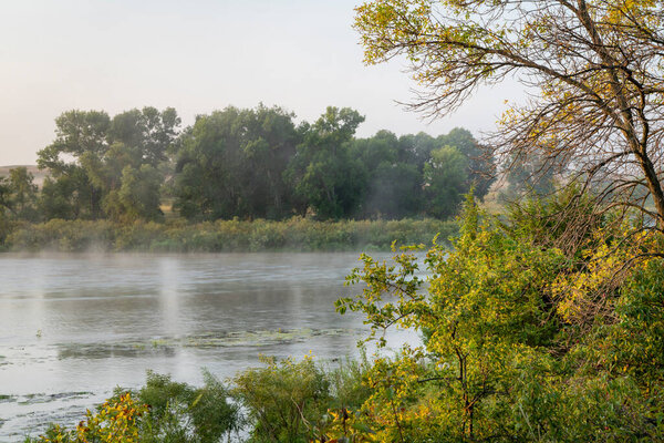 туманный восход солнца над мелководной рекой Дисмал в Национальном лесу Небраска, поздний летний пейзаж