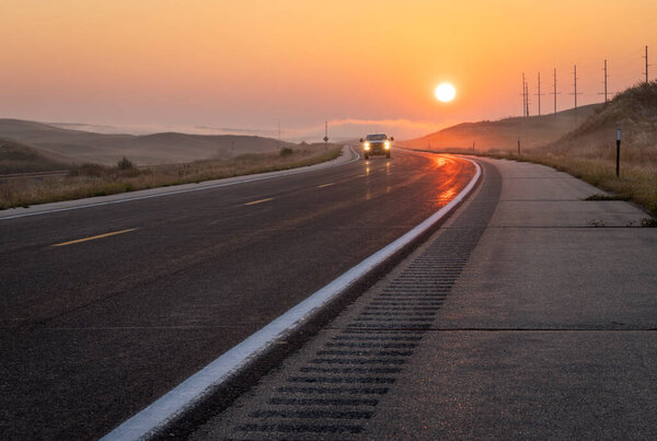 туманный восход солнца над шоссе в Небраске Сэндхиллз возле Маллена
