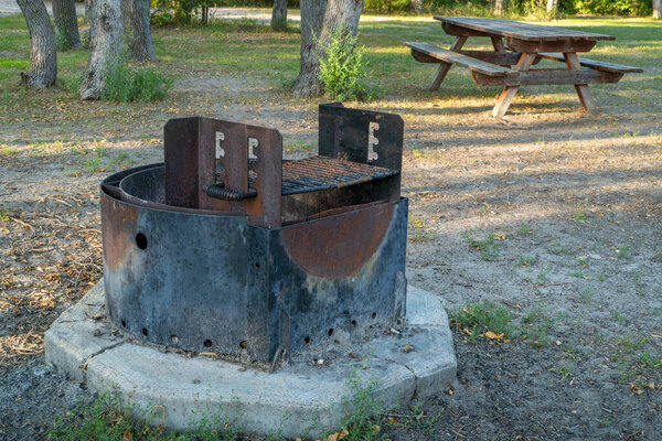 огненное кольцо с грилем для барбекю и выветриваемым деревянным столом для пикника в лагере Уайттейл в национальном лесу Небраска рядом с Хэлси