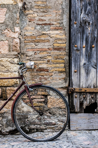 Old bicycle recharged on a rustic wall in a village street of medieval origin in the village of Alquezar in the province of Huesca in Aragon Spain Europe