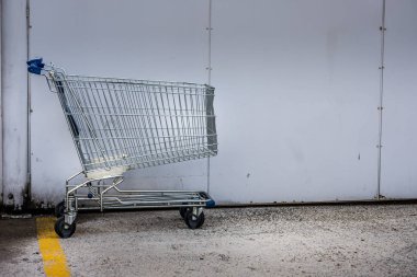 bir duvar bir otoparkın yanında süpermarket arabası