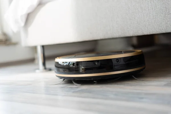 Robot aspirator rulează sub pat — Fotografie, imagine de stoc