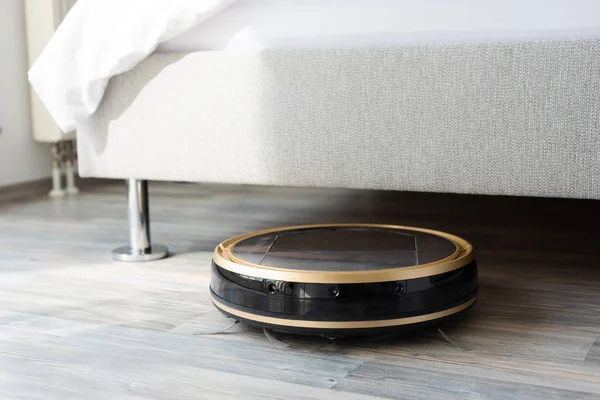 Ηλεκτρική σκούπα ρομπότ τρέχει κάτω από το κρεβάτι — Φωτογραφία Αρχείου