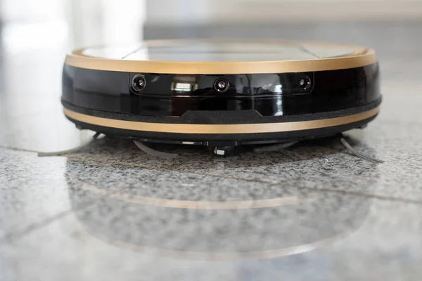 Robotic vacuum cleaner on bright marble floor — Stock Photo, Image