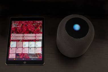 Smart home using an Apple HomePod speaker and the home app on the iPad clipart