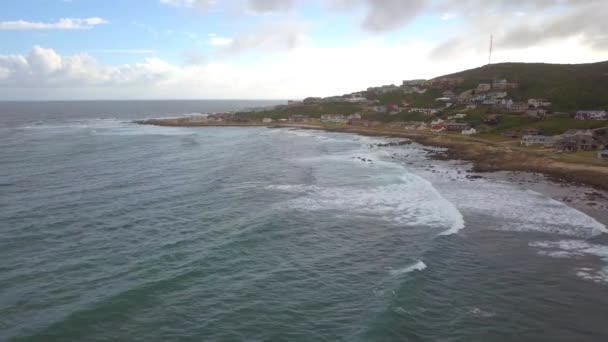 Letecký dron letu podél pobřeží a domy na Jongensfontein — Stock video