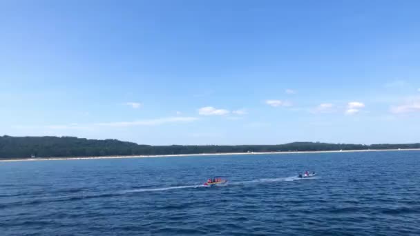 Diversão em uma banana sendo puxada por um barco de velocidade — Vídeo de Stock