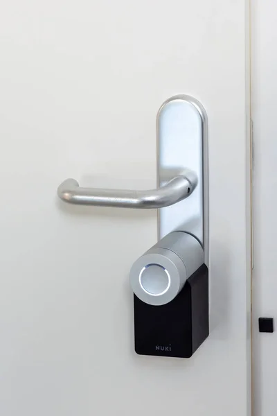 A bejárati ajtó Nuki Smartlock-kal és nyitott ajtóérzékelővel van felszerelve. Intelligens elektronikus zárak használata kulcsmentes hozzáféréssel. — Stock Fotó