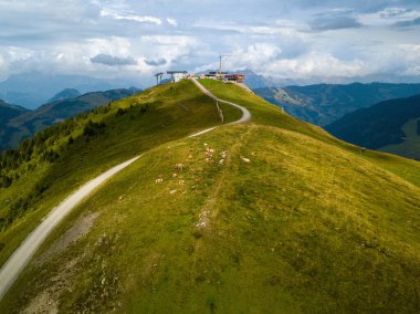 Avusturya Alpleri 'ndeki Hinterglemm' deki Zwoelferkogel dağ istasyonunun havadan görünüşü. Yazın yeni bir restoranın inşaatı devam ediyor ve arka planda büyük bir dağ manzarası var.