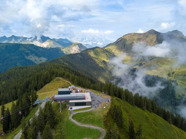 今年夏季，奥地利萨巴纳奇的科尔迈斯山站将成为山地自行车道和徒步旅行者的起点，云中笼罩着宏伟的山地全景 — 图库照片