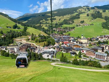 Saalbach köyündeki hava manzarası ve Avusturya 'daki Saalbach-Hinterglemm kayak bölgesindeki dağlar tatil beldeleri, kilise ve diğer tatil beldeleri ile güzel bir yaz günündeydi.