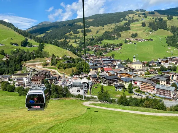 Saalbach köyündeki hava manzarası ve Avusturya 'daki Saalbach-Hinterglemm kayak bölgesindeki dağlar tatil beldeleri, kilise ve diğer tatil beldeleri ile güzel bir yaz günündeydi. — Stok fotoğraf