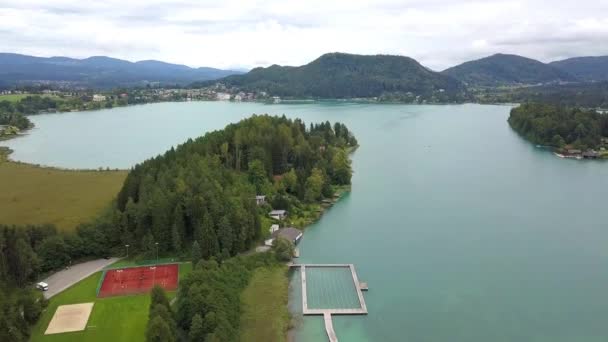 Vista aérea en los extremos superiores del lago Ossiacher en Carintia, Austria en un día de verano con gran paisaje nublado — Vídeo de stock