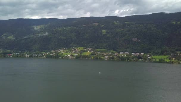 Luftaufnahme vom Ossiacher See in Kärnten, Österreich mit einem Segelboot an einem Sommertag mit toller Wolkenlandschaft — Stockvideo