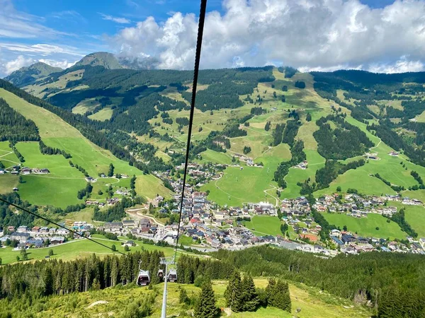 Saalbach köyündeki hava manzarası ve Avusturya 'daki Saalbach-Hinterglemm kayak bölgesindeki dağlar tatil beldeleri, kilise ve diğer tatil beldeleri ile güzel bir yaz günündeydi. — Stok fotoğraf