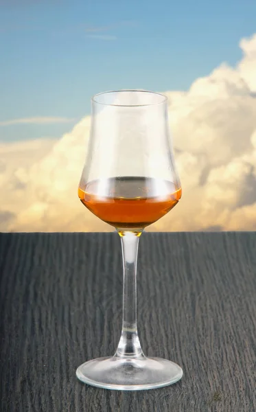 Alkohol Szkło Nad Drewnianym Stole Zachmurzone Niebo Tle Obraz Pionowy — Zdjęcie stockowe