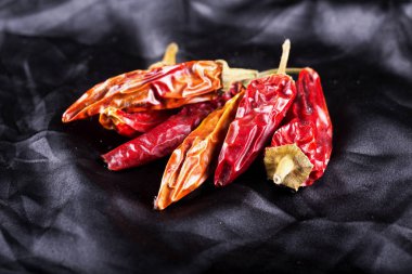 Kurutulmuş kırmızı biberler siyah ipeksi arka plan, yatay görüntü