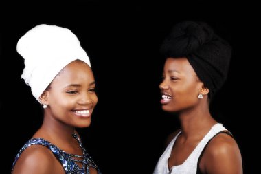 Baş eşarp ile koyu arka plan üzerinde gülümseyen iki Afrikalı-Amerikalı kadın