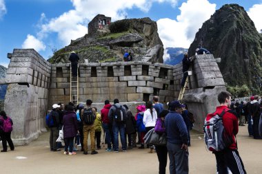 Machu Picchu, Peru - 20 Haziran 2015: Güney Amerika turist İnka taş duvar restorasyon çalışmalarına izlerken Harabeleri