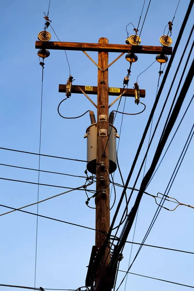 有蓝天和穿越电缆的木制电力线电线杆 — 图库照片