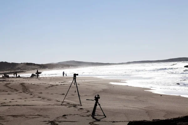 Силуэт фото и видео камер на штативах на пляже с О — стоковое фото