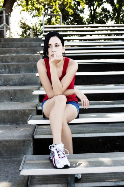 屋外の金属漂白剤に座っている魅力的なヒスパニック女性 — ストック写真