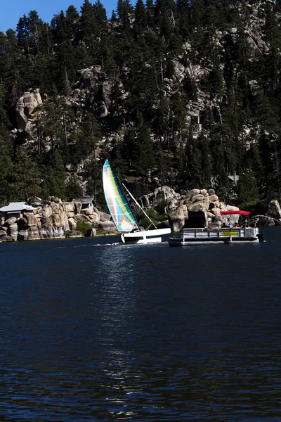 Catamaran zeilen op het meer in de buurt van ponton boot motoring — Stockfoto