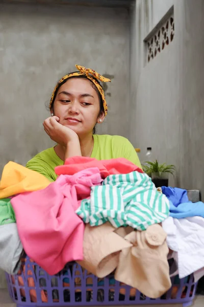 Perezosa mujer asiática adulta en frente de la cesta llena de lavandería — Foto de Stock