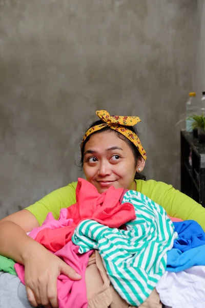 Jovem mãe asiática feliz com uma cesta cheia de roupa — Fotografia de Stock