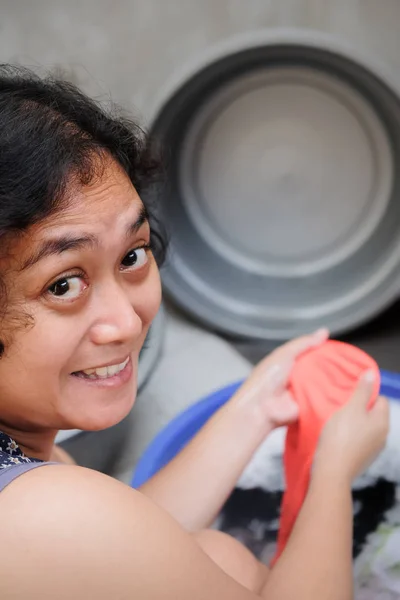 Mãe asiática feliz lavandaria em casa. Lavagem das mãos — Fotografia de Stock