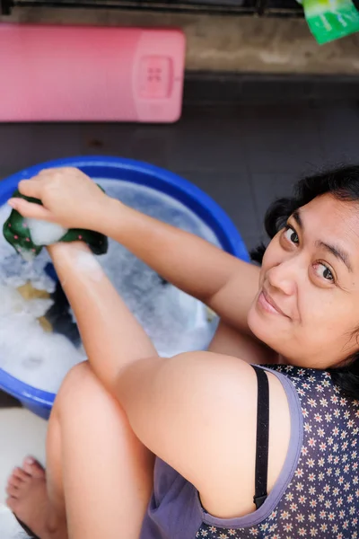 Asiática mujer adulta disfrutar haciendo lavandería en casa. Lavado de manos —  Fotos de Stock