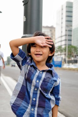 Neşeli Asyalı çocuk Aşağı Town aile gezisi sırasında Şehir Caddesi yakınında eğlenmek