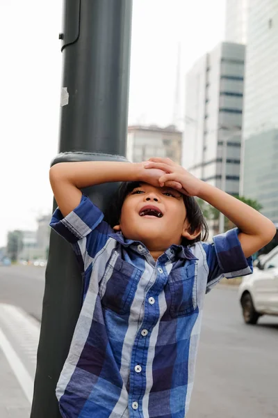 Alegre ásia menino brincando em torno de próximo cidade rua durante família viagem para cidade centro — Fotografia de Stock