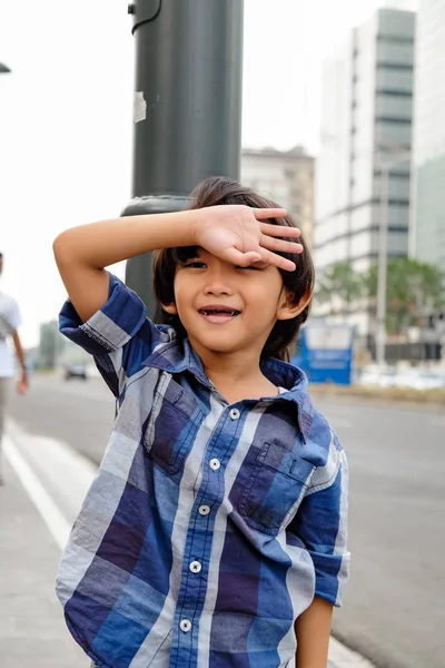 Neşeli Asyalı çocuk Aşağı Town aile gezisi sırasında Şehir Caddesi yakınında eğlenmek