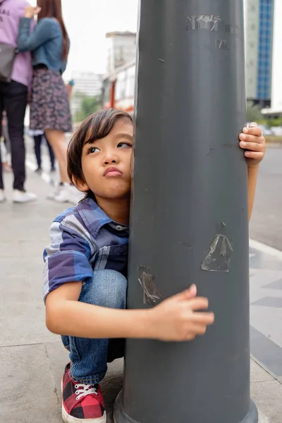 Азиатский ребенок скулит и капризничает, требуя чего-то во время семейной поездки — стоковое фото