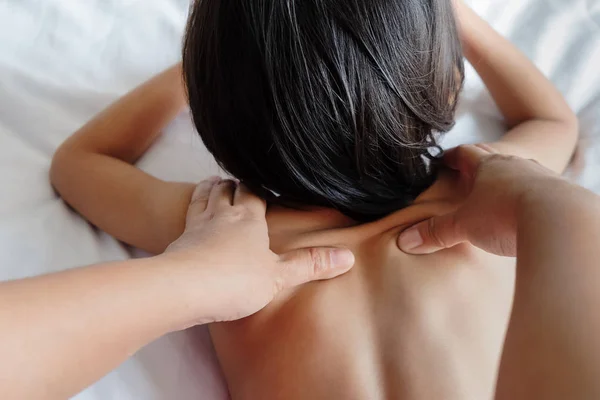 Mulher dando um menino massagem terapia no ombro para dar-lhe Rela — Fotografia de Stock