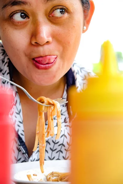 एक आशियाई प्रौढ महिला चेहर्याचा अभिव्यक्ती जे खरोखर तिच्या आवडत्या अन्न खाण्याचा आनंद घेतात — स्टॉक फोटो, इमेज