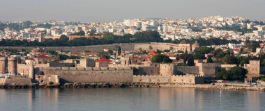 Rhodes, Yunanistan - 19 Mayıs 09: Mandraki Limanı Rodos, Yunanistan. Setin içinde her bir Rodos Eski Liman girişine bakıldığında. Cruiseliners ve diğer ziyaretçiler için sık kullanılan hedefler