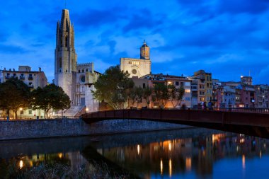 City of Girona Old Town skyline at night with Basilica and Bridge of Sant Feliu, historic houses and Cathedral at Onyar River, Catalonia, Spain clipart