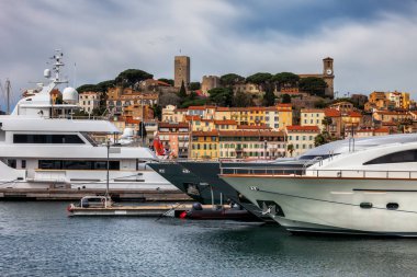 Cannes city in France, luxury yachts at Le Vieux Port on French Riviera, the Old Town - Le Suquet in the background clipart