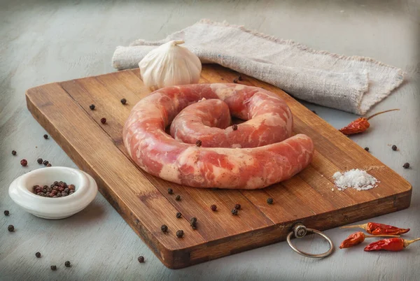 Anillo Salchicha Cruda Una Tabla Cortar Con Pimienta Ajo Cocina — Foto de Stock