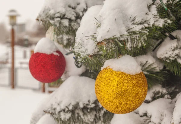 雪に覆われた人工のクリスマスツリーで 通りにボールがあります — ストック写真
