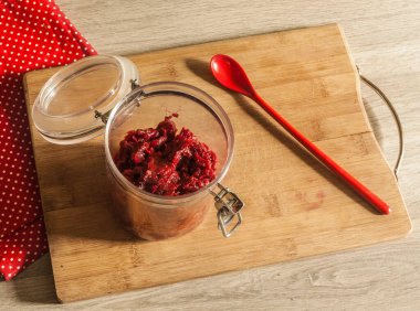 Elma, pancar, soğan ve baharat kavanozunu gri bir masada yuvarlak bir kesim tahtasında aç..