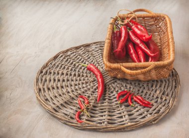 Gri bir masada, sepetin içinde kırmızı biber kabukları..